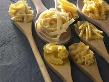 Close-up of raw pasta and wooden spoon on table