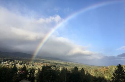 Scenic view of rainbow over landscape against sky