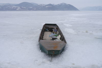 Scenic view of sea by snowcapped mountains during winter