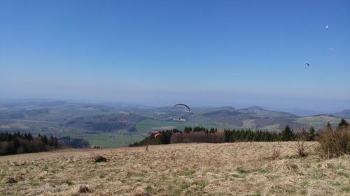 Hot air balloon flying over landscape against sky