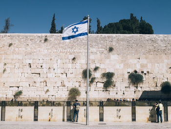 Israeli flag waving against western wall