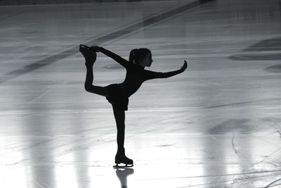 Full length of girl ice-skating on rink