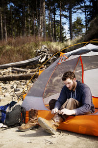 Man wearing shoes while sitting in tent