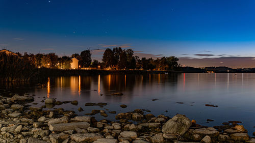 Scenic view of lake against blue sky at night