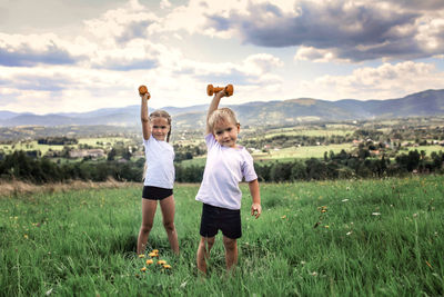 Boy standing on field against sky