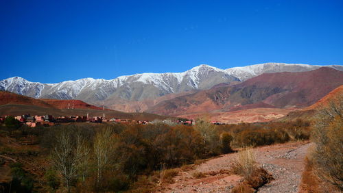 Scenic view of landscape and mountains against blue sky