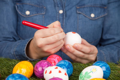 Midsection of woman coloring easter eggs