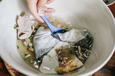 Close-up of hand holding ice cream in bowl