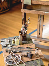 High angle view of paint equipment on wooden table