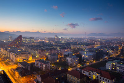 High angle view of illuminated city against sky at sunset