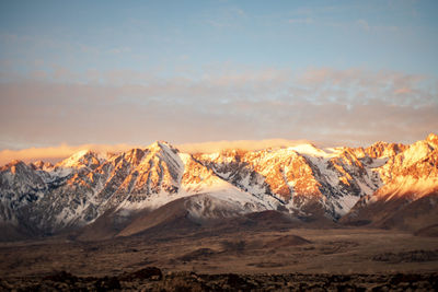 Scenic view of snowcapped mountains against sky during sunset