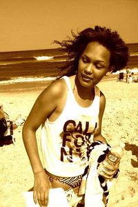 Smiling young woman standing on beach