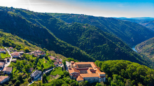 Houses by trees and mountains against sky