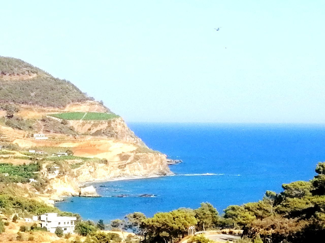 SCENIC VIEW OF SEA AND ROCKS AGAINST CLEAR SKY