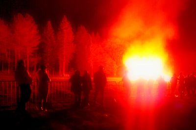 Silhouette of people on fire at night