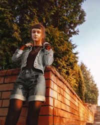 Full length of woman standing against tree