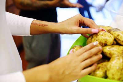 Cropped image of woman touching potatoes