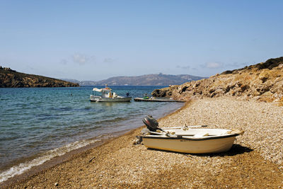 Sailboats moored on sea against clear sky