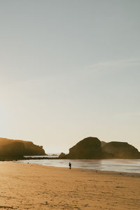 Scenic view of sea against clear sky couple standing along the coast of sand dollar beach in bug sur