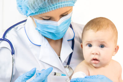 Doctor giving vaccine to baby at clinic