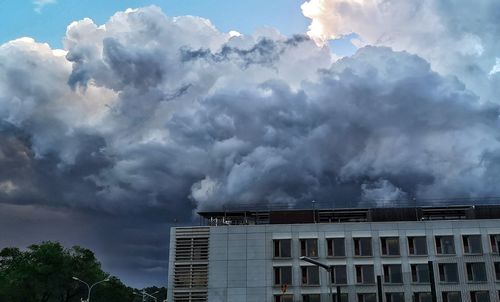 Low angle view of smoke emitting from building against sky