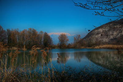 Scenic view of lake against clear blue sky