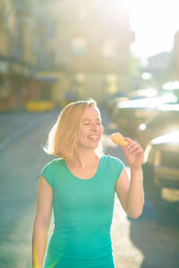 Young woman eating ice cream outdoors