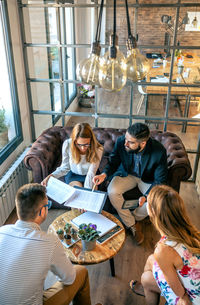 High angle view of people sitting on table