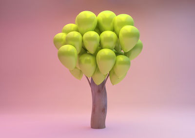 Close-up of multi colored balloons against pink background