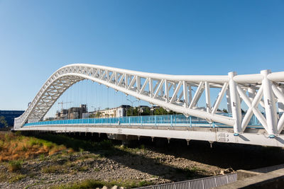 Bridge over river against clear blue sky