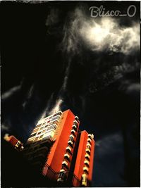 Low angle view of illuminated skyscraper against sky at night