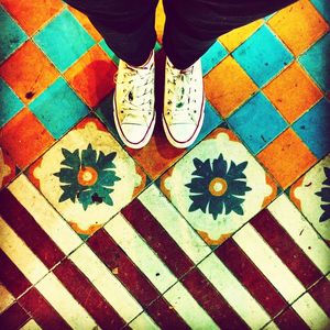 Low section of man standing on tiled floor