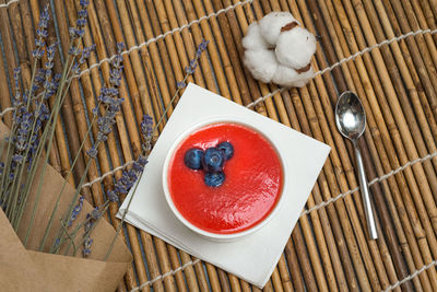 Panna cotta with raspberry coulis. the dessert is garnished with blueberries.