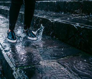 Low section of person standing in puddle