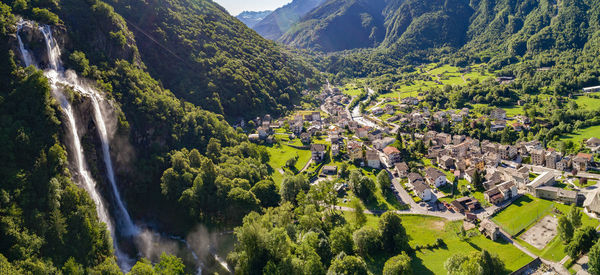 Scenic view of village amidst trees and mountains