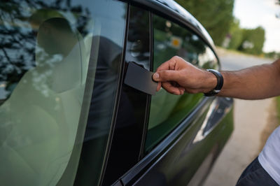 Cropped hand of man photographing in car