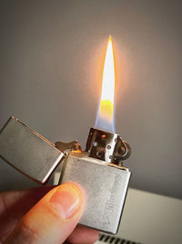 Close-up of hand holding lit candle