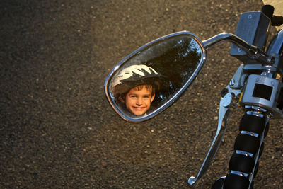 Reflection of boy on side-view mirror