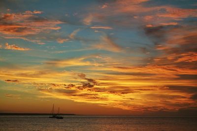 Boat sailing in sea at sunset