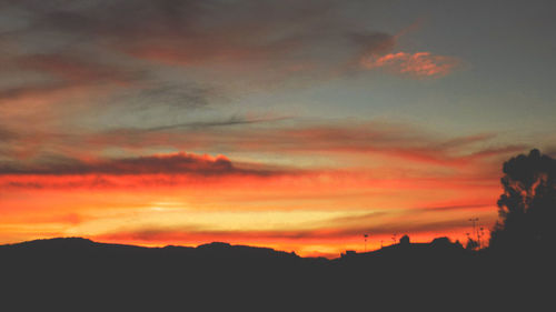 Scenic view of silhouette mountains against dramatic sky