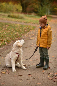 Boy and dog in the park look at each other