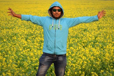 Portrait of young man wearing sunglasses standing on field