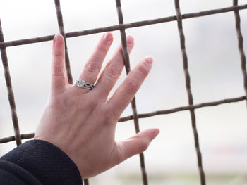 Close-up of human hand against sky