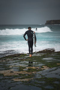 Full length of man standing on beach against sky