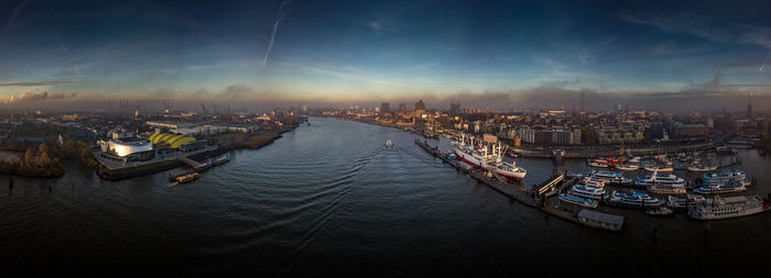 High angle view of sailboats moored in sea against sky during sunset