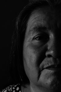 Close-up portrait of a woman against black background