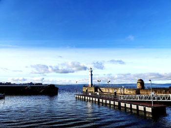 Pier over sea against blue sky