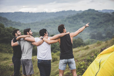 Group of people with arms raised on mountain