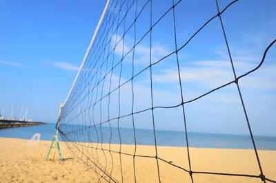 Close up of volleyball net with sea beach and blue sky in summer.