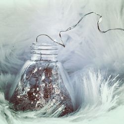 String light in jar on feathers 